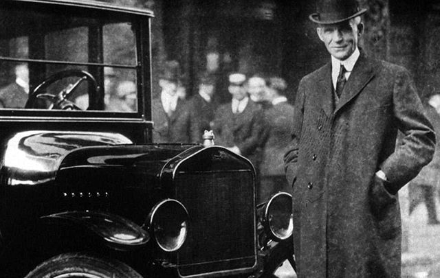 Proud of his Irish roots, Henry Ford, photographed with a model T Ford.