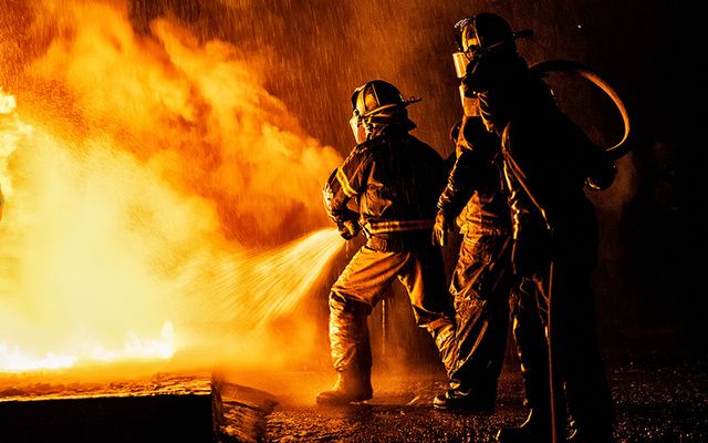 Firefighters attempting to put out a burning building. 