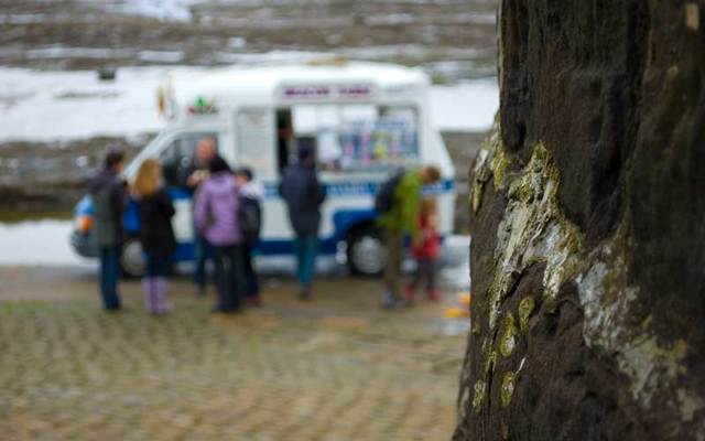 People buying ice cream from a van.