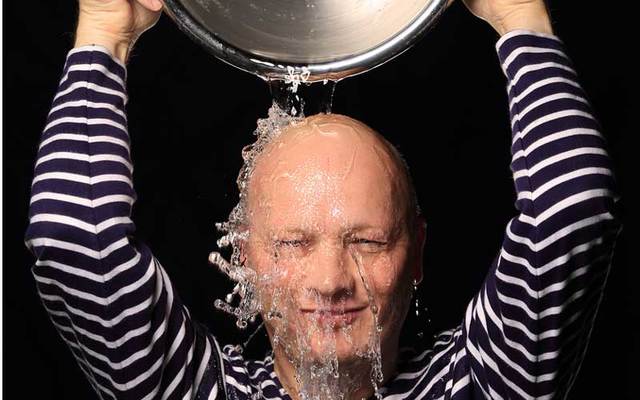 A man pours cold water over his head.