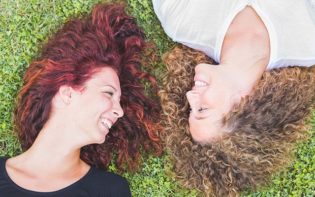 Redhead women lying on the grass.