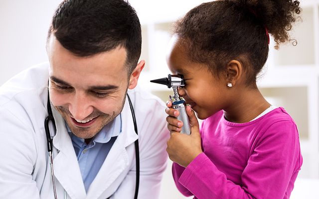Doctor and little girl laughing. 