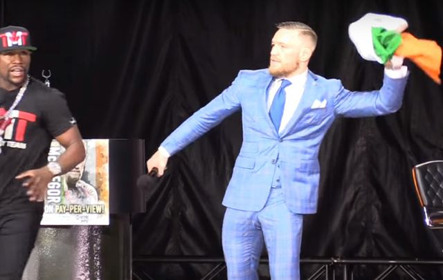 MMA champ Conor McGregor throwing the Irish flag to the ground at Floyd Mayweather\'s feet.