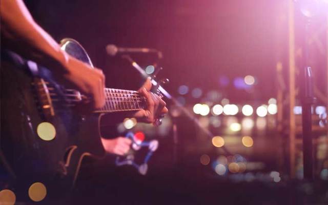 Hands playing a guitar.