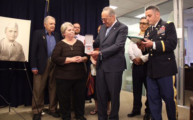 Senator Schumer presenting the medal to Bernard J. McNamara’s son, Brian, his daughter Catherine, grandson Matthew, and granddaughter Christine.