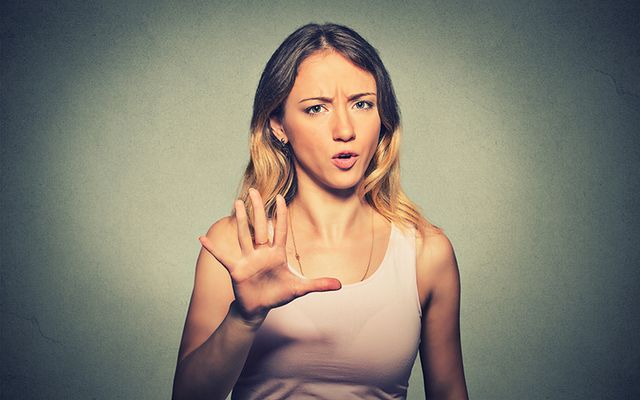 A woman holding up her hand to stop. 