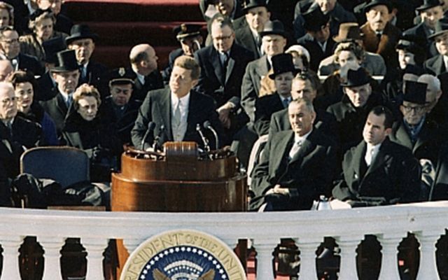 President John F Kennedy give his inauguration speech in 1960, flanked by Lydon B Johnson and Richard Nixon.