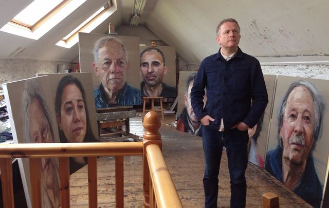 Colin Davidson surrounded by his portraits.