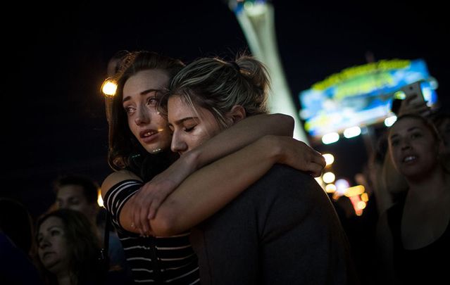 Survivors huddle in the wake of the murder of 59 people and shooting of over 100 others. 