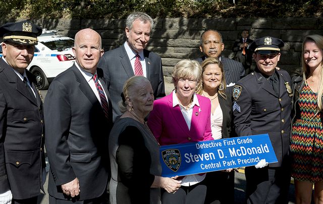 Patti Ann McDonald holds the sign in her husband’s honor in Central Park last week.