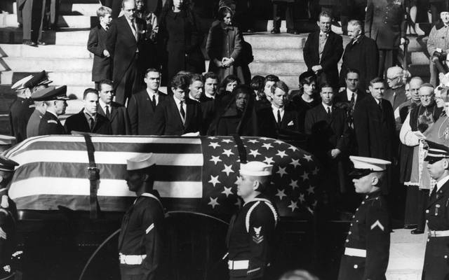 Jacqueline Kennedy, Edward Kennedy and Robert Kennedy stand as the coffin of President John Fitzgerald Kennedy passes them
