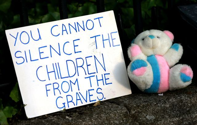 A sign posted in front of Ireland\'s government building in protest of the Tuam babies mass grave - \"You cannot silence the children from the graves.\"
