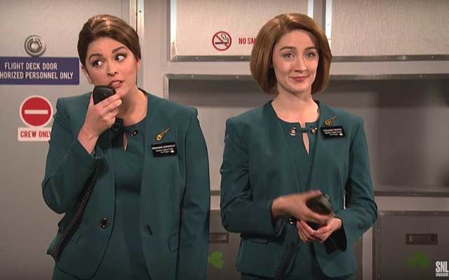 Screen shot of Aer Lingus skit on SNL, with Cecily Strong and Saoirse Ronan as flight attendants.