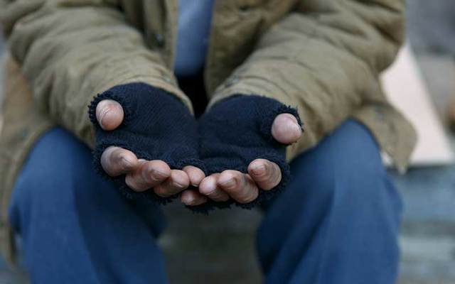 A beggar holds out his hands.