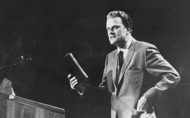 American evangelist Billy Graham, giving a speech on stage, circa 1970