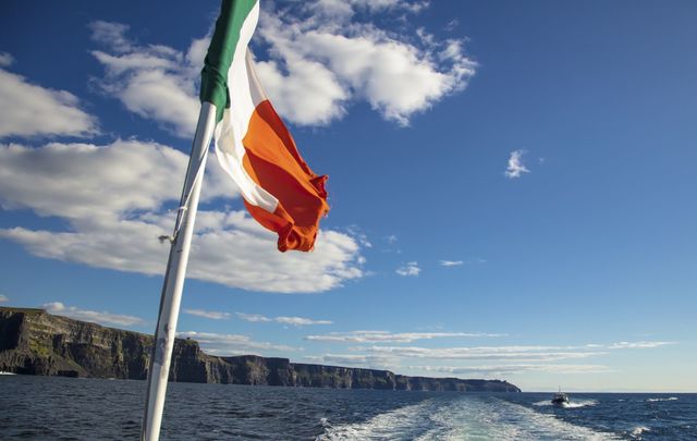 Scenic view of the Cliffs of Moher, Liscannor, Ireland, with the Irish flag tricolor. 