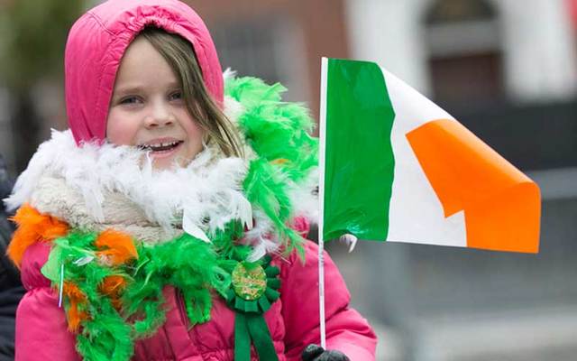 A little girl bundled up in the cold for St Patrick\'s Day celebrations.