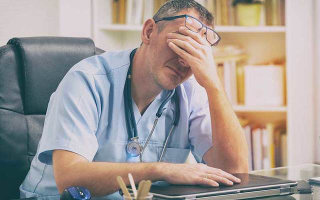 Overworked doctor at his desk.