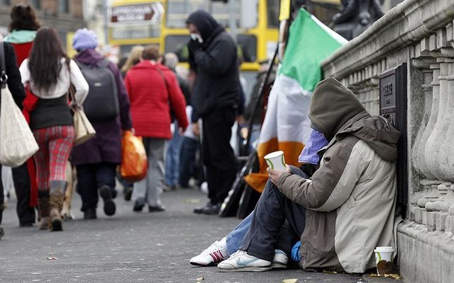 A homeless couple begging on O\'Connell Bridge, Dublin.