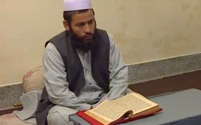 Islamic teacher in front of the Koran.