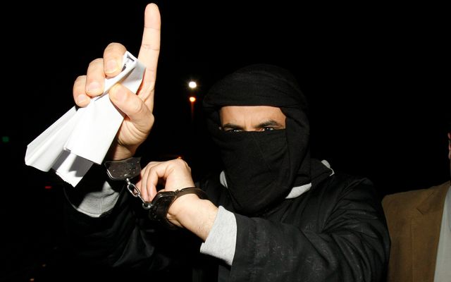 Ali Charafe Damache (L) of Algeria arrives with Irish Police to the Waterford District Court in Waterford, Ireland on March 15, 2010, after being charged. Damache was one of two men in custody in connection with an alleged plot to murder cartoonist Lars Vilks over a picture of the Prophet Mohammed with the body of a dog. 