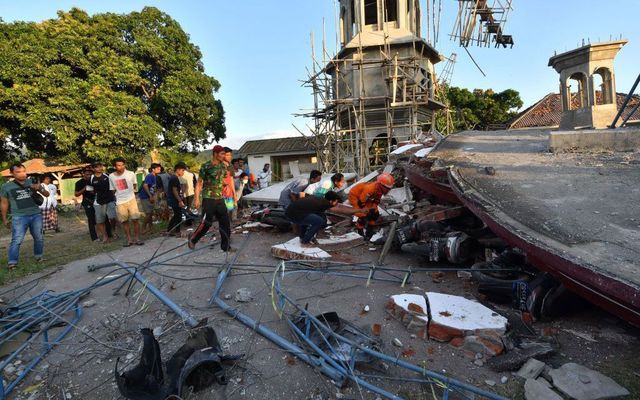 Residents an Indonesian search and rescue personnel look under the ruins of a mosque in Pemenang, North Lombok on August 6, 2018, the day after a 6.9 magnitude earthquake struck the area. - More than 1,000 tourists were being evacuated from Indonesia\'s tiny Gili islands on August 6 after a powerful quake struck neighboring Lombok, killing 91 people and injuring hundreds