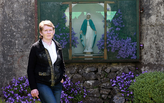 Amateur historian Catherine Corless standing in front of a shrine, built by locals, on the site where 796 children were buried in a mass grave in Tuam, Galway.