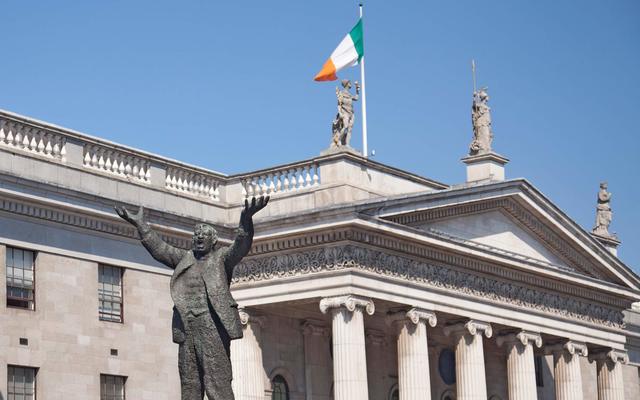 Statue of Jim Larkin on O\'Connell Street in the center of Dublin with the General Post Office building in the background.