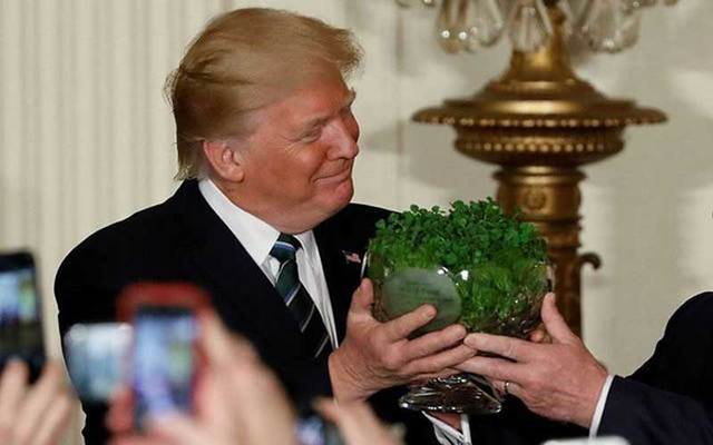 President Donald Trump being presented with a bowl of shamrocks on St. Patrick\'s Day.