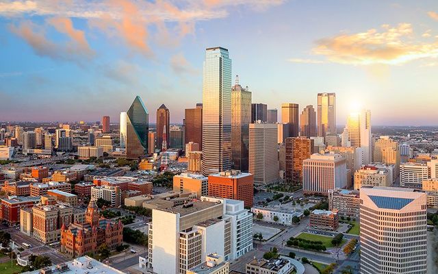 Dallas skyline reflected in Trinity river at sunset. 