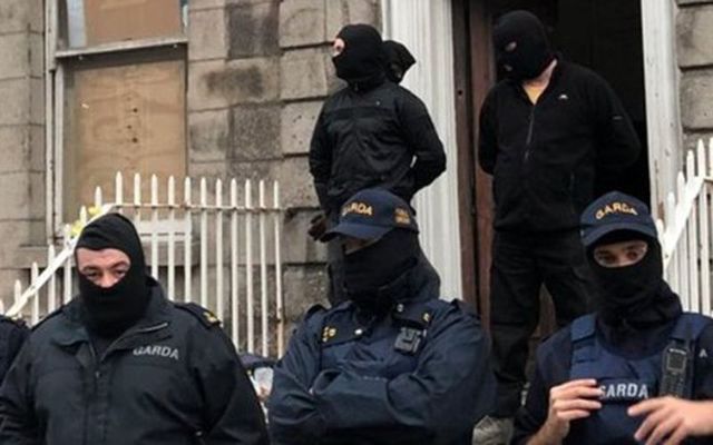 Masked men remove activists from an empty lot. 