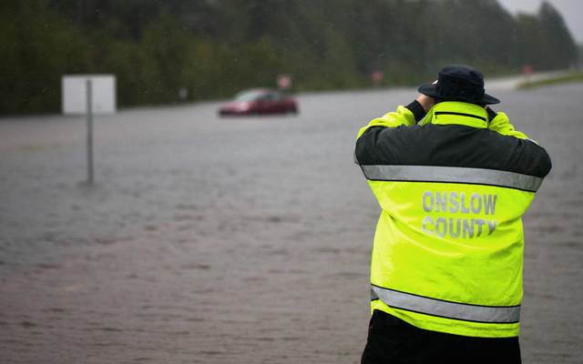 Members of Onslow County emergency look to see if a passenger was still in a car that was overtaken by flooding on US Route 17 outside of Jacksonville, North Carolina on September 15, 2018, during Tropical Storm Florence.