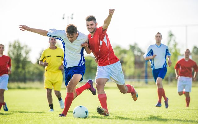 Soccer players practicing soccer on a playing field.\n