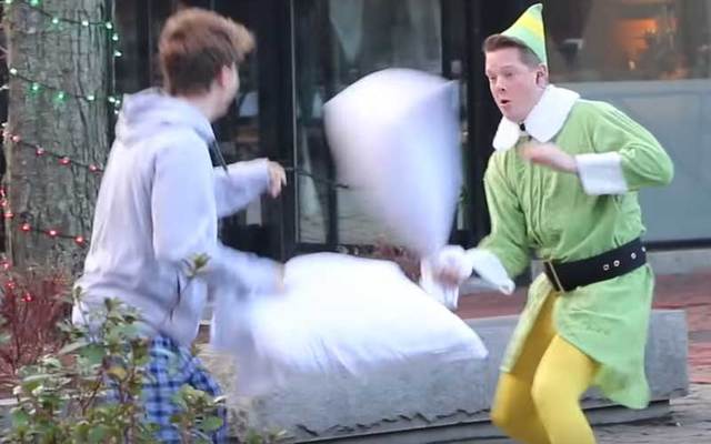 Firefighter Brendan Sullivan, dressed as Buddy the Elf, challenges a stranger to a pillow fight in Boston.