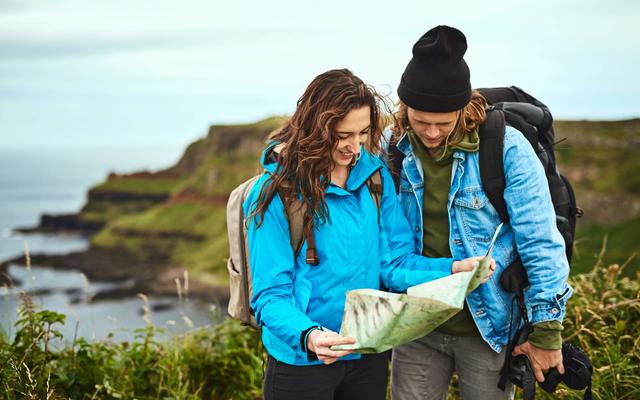 Shot of a young couple looking at a map for directions outdoors. 