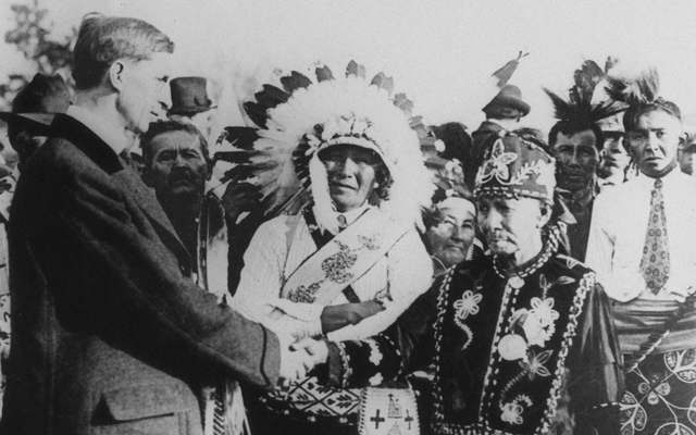 Irish politician and president of Dail Eireann, Eamon de Valera (1882 - 1975, left), shakes hands with Native Americans during a visit to the USA, 1919.