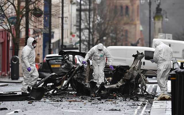 Forensic officer inspect the remains of the vehicle used as a car bomb outside the court house in Derry on Saturday, January 20.