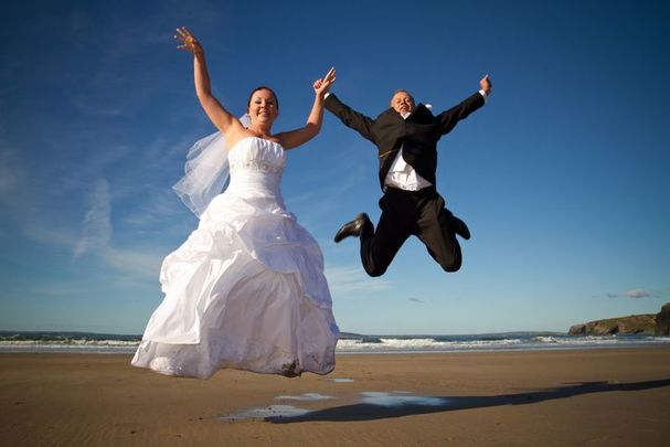Happy Irish wedding couple celebrating on a beach. 