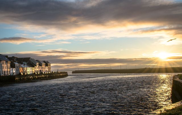 A picture of Galway Harbor in Ireland at sunrise.\n