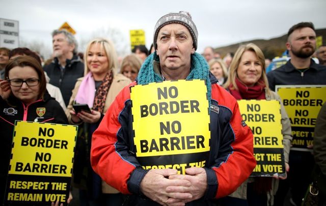 Protesters against any border between Ireland and Northern Ireland because of Brexit hold placards at the Carrickcarnan border between Newry in Norther Ireland and Dundalk in the Irish Republic on March 30, 2019.