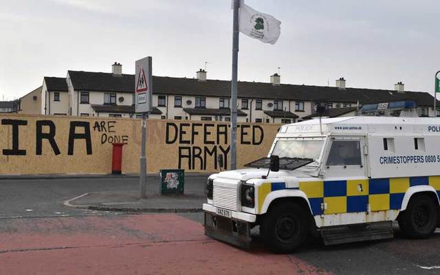 Police van parked near graffiti which says \'IRA are done\' and \'Defeated Army\' in Derry, Northern Ireland.
