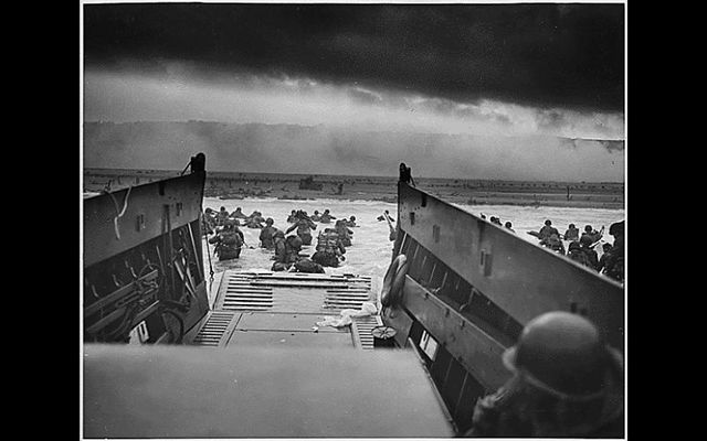 \"Into the Jaws of Death - U.S. Troops wading through water and Nazi gunfire\"