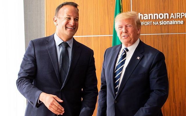 US President Donald Trump signs the visitors\' book as Taoiseach Leo Varadkar (L) and First Lady Melania Trump (R) watch on at Shannon Airport on June 5, 2019, in Shannon, Ireland.