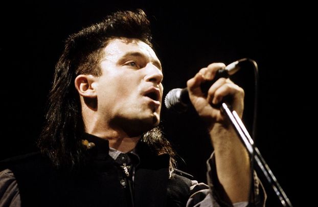 Bono performing live onstage on The Unforgettable Fire tour, at \'The Longest Day\' concert. 