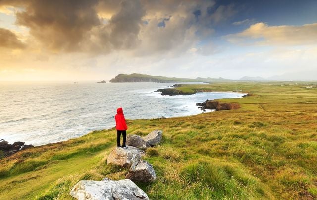 A woman exploring the coastline near Sybil head along the Dingle peninsula. 