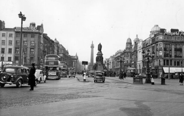 April 1952: O\'Connell Bridge and O\'Connell Street, Dublin, with the O\'Connell Monument and Nelson Pillar in the center. \n