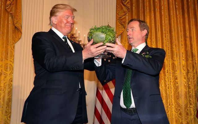 Donald Trump receiving a bowl of shamrock from Enda Kennedy on St. Patrick\'s Day in 2017. 