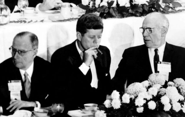 President John F. Kennedy smoking a cigar. 