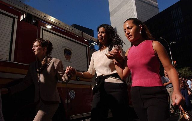  Civilians flee the area as a tower of the World Trade Center collapses September 11, 2001, in New York City after two airplanes slammed into the twin towers in an alleged terrorist attack.