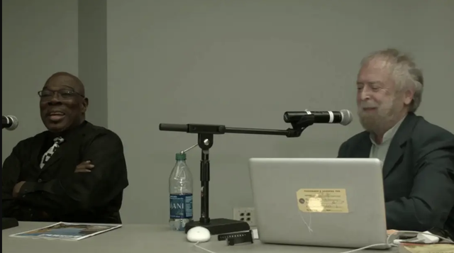 Lenwood Sloan and Paddy Moloney speaking at the \"Black-Irish Identities: A Symposium” at Glucksman Ireland House, New York.